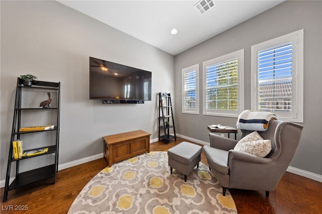 living area featuring baseboards, visible vents, wood finished floors, and recessed lighting