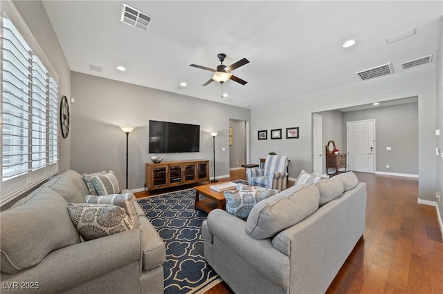 living room with a ceiling fan, dark wood finished floors, visible vents, and baseboards