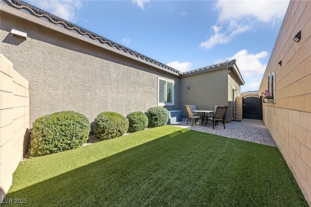 view of yard with a patio area, fence, and a gate