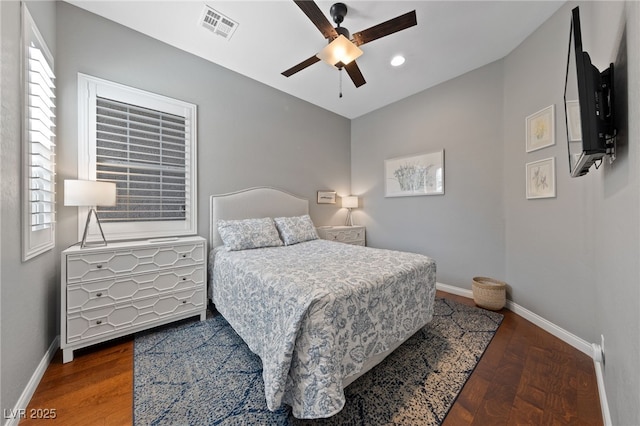 bedroom with visible vents, baseboards, and wood finished floors