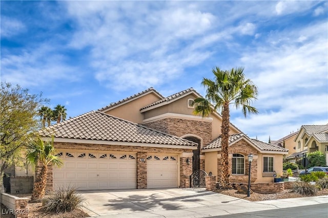 mediterranean / spanish-style home featuring an attached garage, stucco siding, concrete driveway, stone siding, and a tile roof