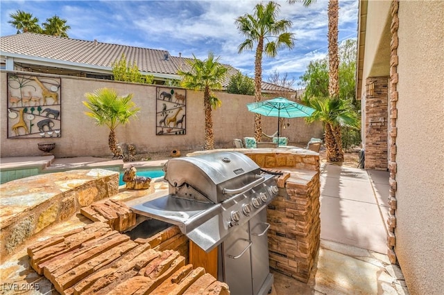 view of patio / terrace with area for grilling and a fenced backyard