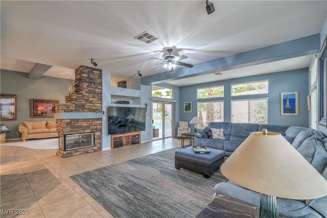 tiled living room featuring visible vents, a stone fireplace, and ceiling fan