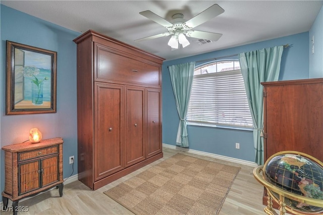 bedroom featuring visible vents, baseboards, light wood-style floors, and a ceiling fan