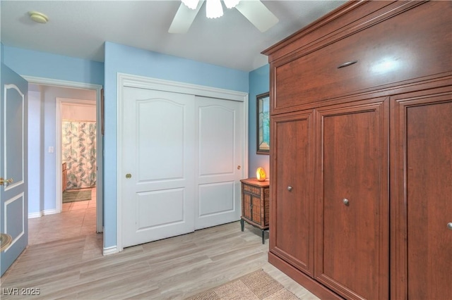 bedroom with a closet, light wood-type flooring, and a ceiling fan