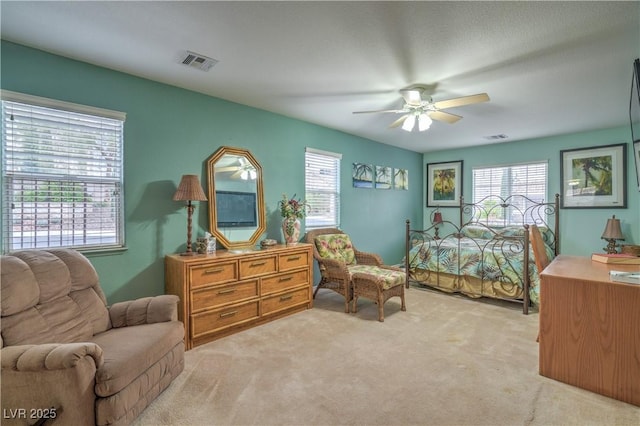 bedroom featuring multiple windows, visible vents, and light carpet