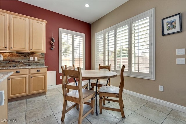 dining room featuring baseboards, a wealth of natural light, and light tile patterned floors