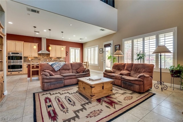 living area featuring light tile patterned flooring, baseboards, and visible vents