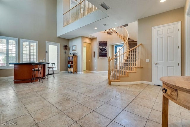 foyer featuring light tile patterned floors, baseboards, stairs, recessed lighting, and a notable chandelier