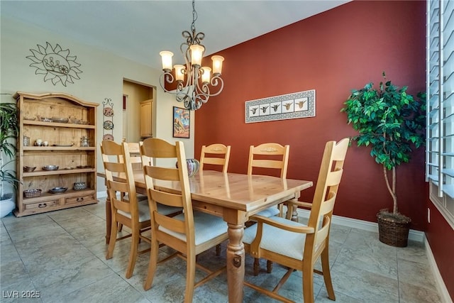 dining area with baseboards and a chandelier