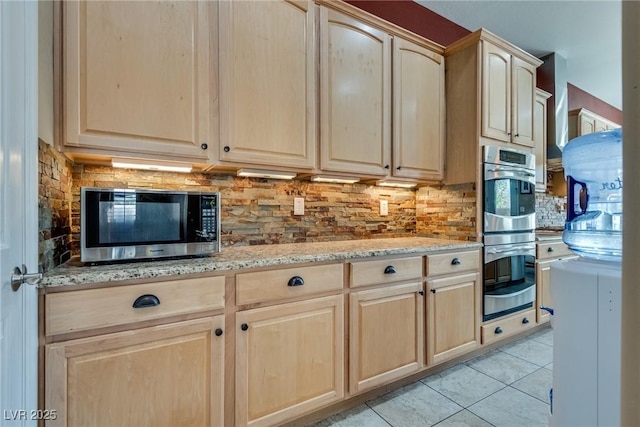 kitchen featuring decorative backsplash, light tile patterned flooring, appliances with stainless steel finishes, and light brown cabinetry