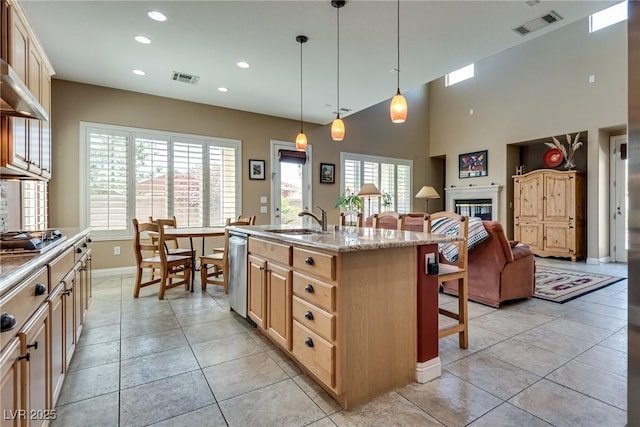 kitchen with a sink, a breakfast bar area, open floor plan, stainless steel appliances, and visible vents