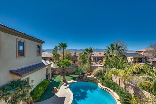 view of swimming pool featuring a fenced backyard, a fenced in pool, a mountain view, and a residential view