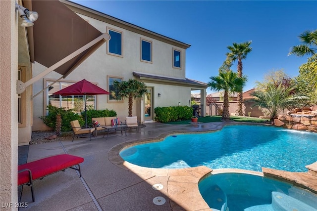 view of pool with fence, a pool with connected hot tub, and a patio area