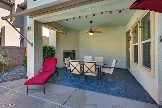 view of patio featuring outdoor dining area and a ceiling fan