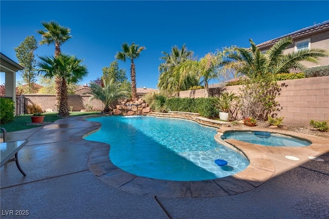 view of pool featuring a fenced backyard, a pool with connected hot tub, and a patio area