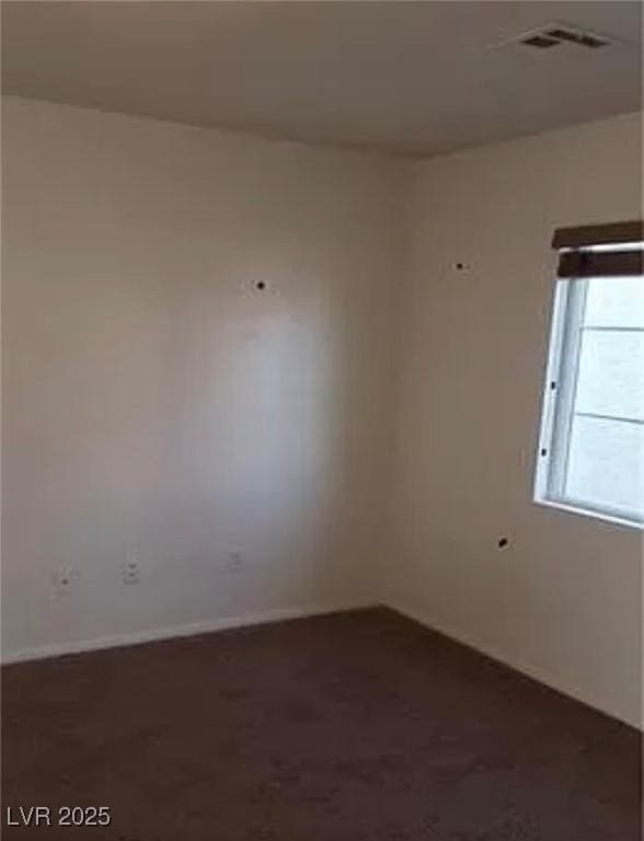 unfurnished room with visible vents