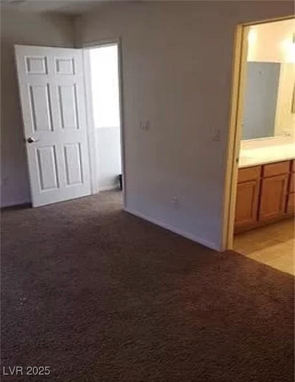 unfurnished bedroom featuring connected bathroom and light colored carpet