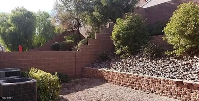 view of yard featuring fence and central air condition unit