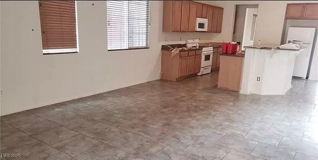 kitchen with dark countertops, white appliances, and a center island