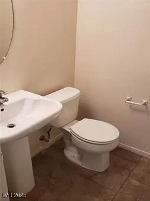 bathroom featuring toilet and baseboards