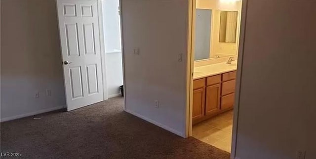 interior space featuring ensuite bath, carpet, and baseboards