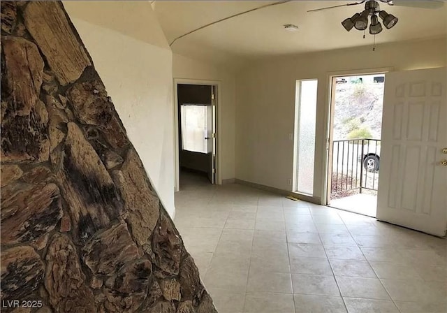 interior space with light tile patterned floors and a ceiling fan