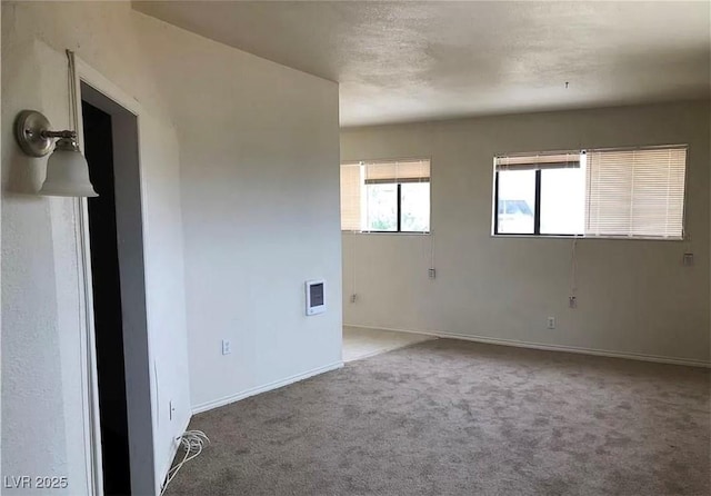 carpeted spare room featuring baseboards