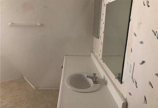 bathroom with baseboards and a sink