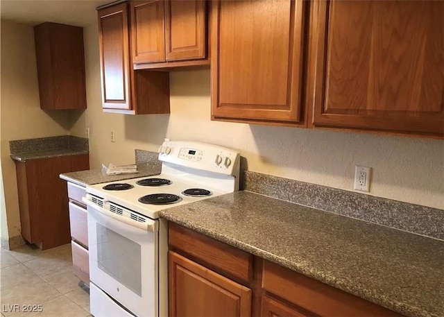 kitchen with brown cabinets, electric stove, and light tile patterned flooring