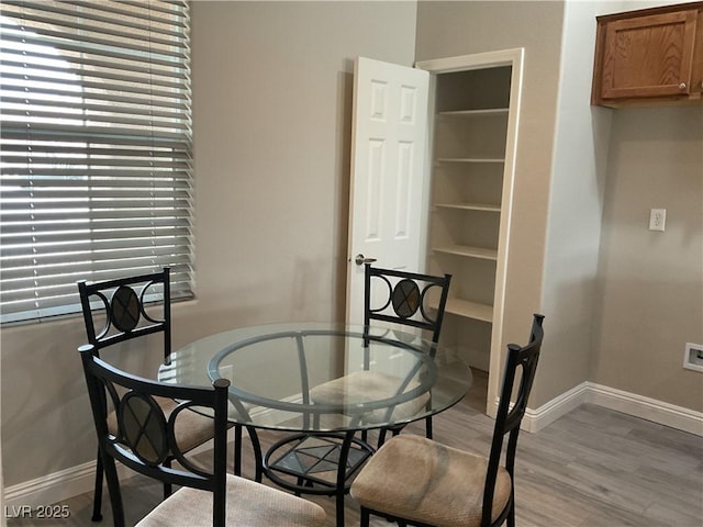 dining space with wood finished floors and baseboards