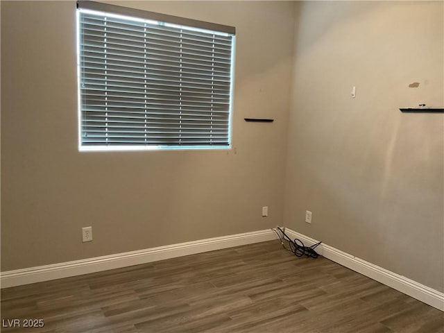 empty room with baseboards and wood finished floors