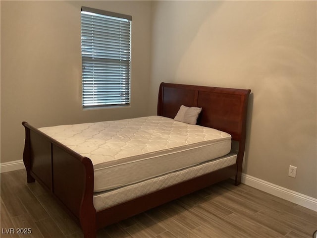 bedroom featuring baseboards and wood finished floors