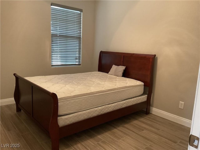 bedroom with baseboards and wood finished floors