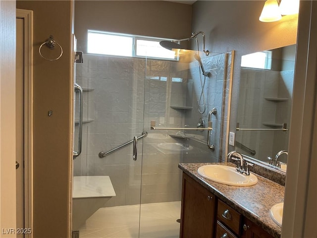 bathroom with double vanity, a stall shower, and a sink