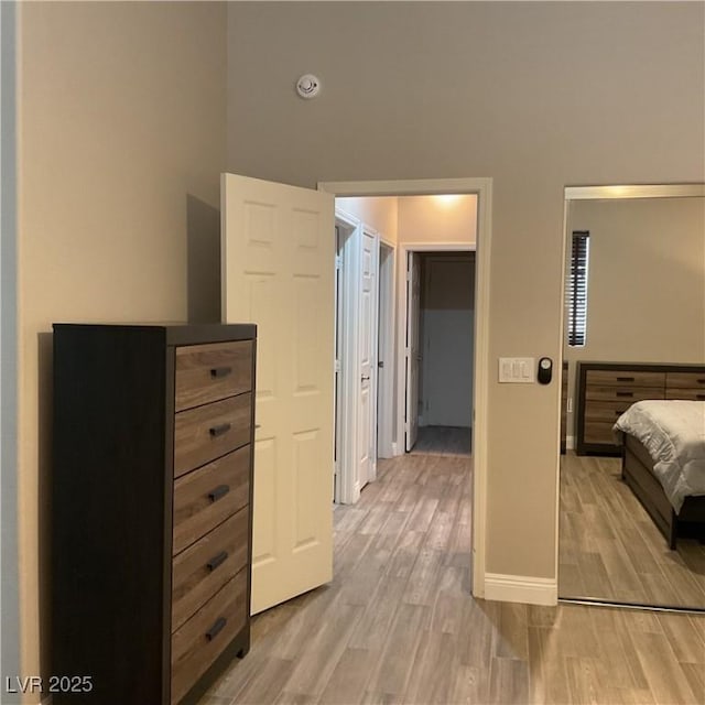 bedroom featuring baseboards and light wood finished floors