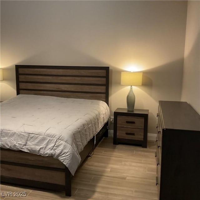 bedroom with baseboards and wood finished floors