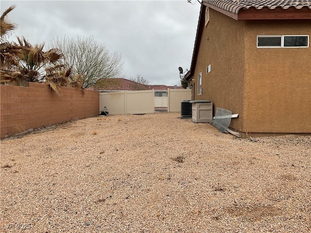 view of yard featuring central AC unit and fence