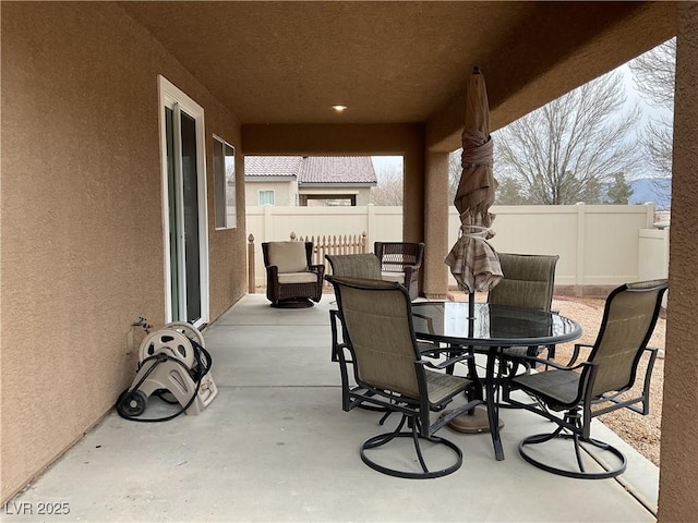 view of patio featuring fence and outdoor dining space