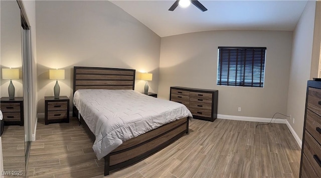 bedroom with light wood-style floors, lofted ceiling, baseboards, and a ceiling fan