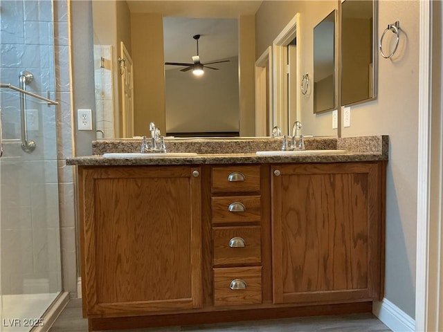 bathroom featuring a sink, ceiling fan, and a shower stall