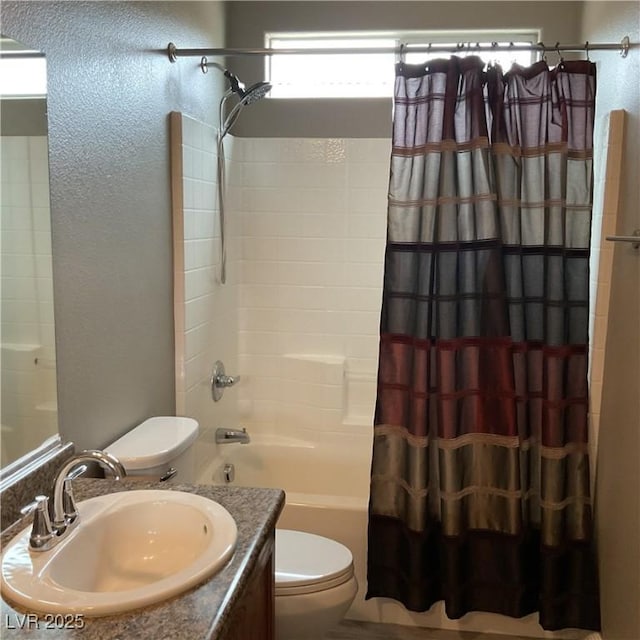 bathroom with a textured wall, vanity, shower / bath combo with shower curtain, and toilet