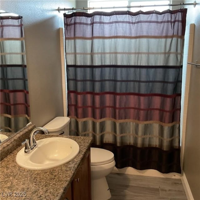 full bath featuring a shower with curtain, vanity, toilet, and wood finished floors