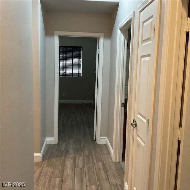 hallway with baseboards and wood finished floors