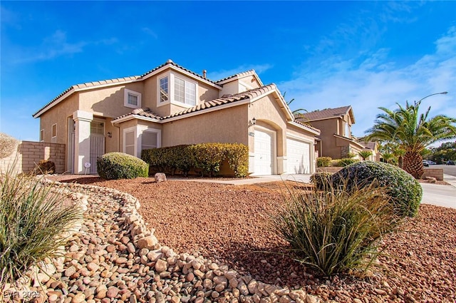 view of front facade with an attached garage, driveway, fence, and stucco siding