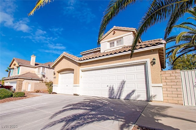 mediterranean / spanish-style house with an attached garage, a tile roof, concrete driveway, and stucco siding