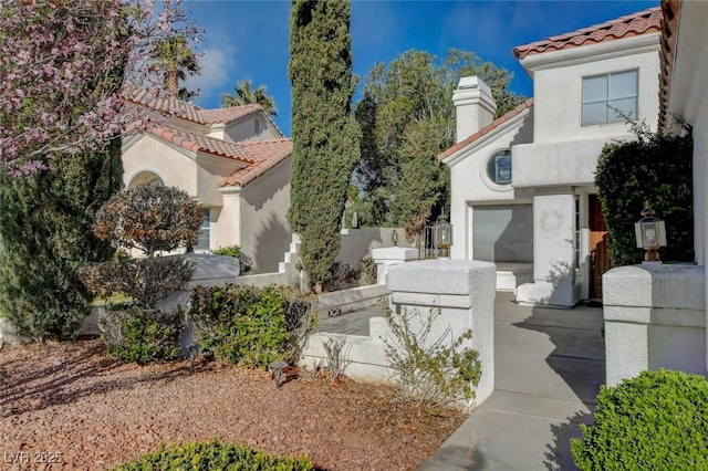 view of front of home with a garage, a tiled roof, and stucco siding