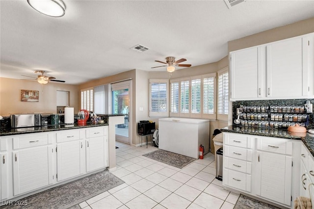 kitchen with light tile patterned floors, ceiling fan, and white cabinetry