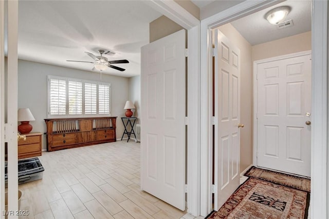 foyer entrance with light wood-style floors, visible vents, and a ceiling fan