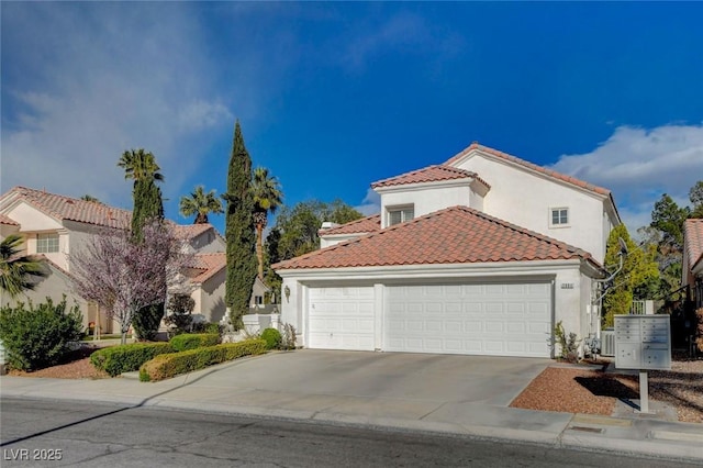 mediterranean / spanish home with an attached garage, driveway, a tile roof, and stucco siding